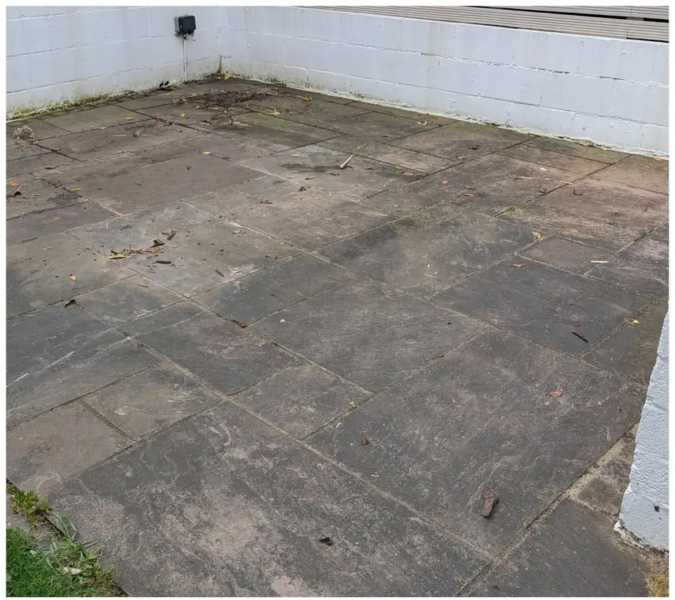 Dirty sandstone patio flags before cleaning