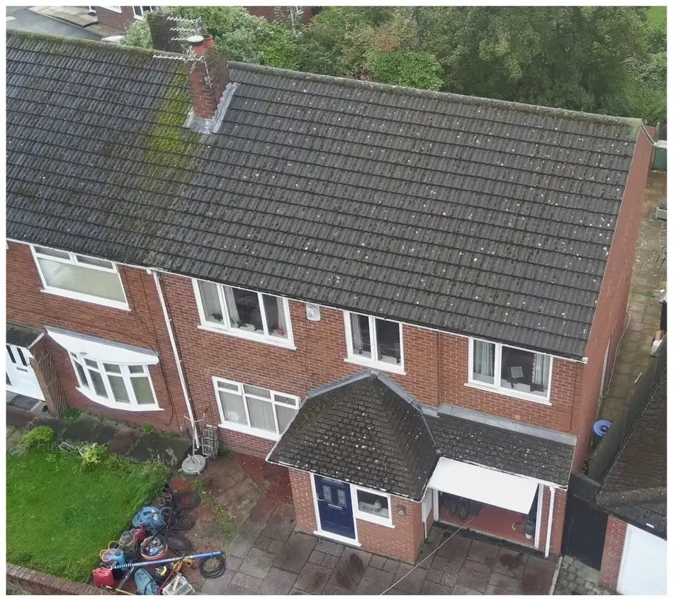 Moss and algae covered tiled roof before cleaning